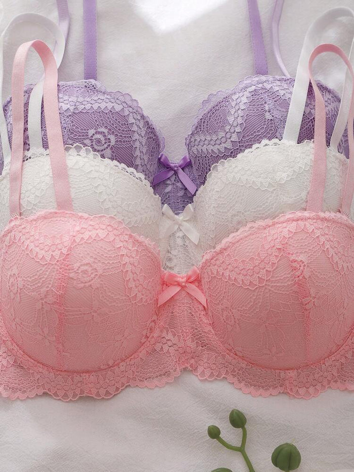 Pink and white lace bra with a purple background