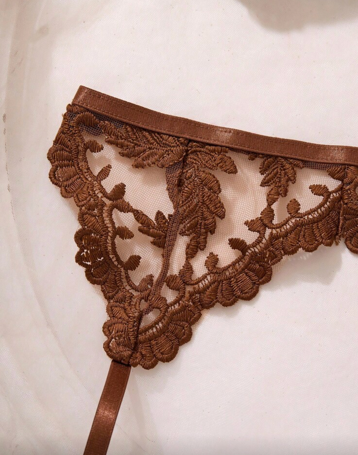A close-up of a brown lace thong with a matching brown waistband garter, shown against a light background.