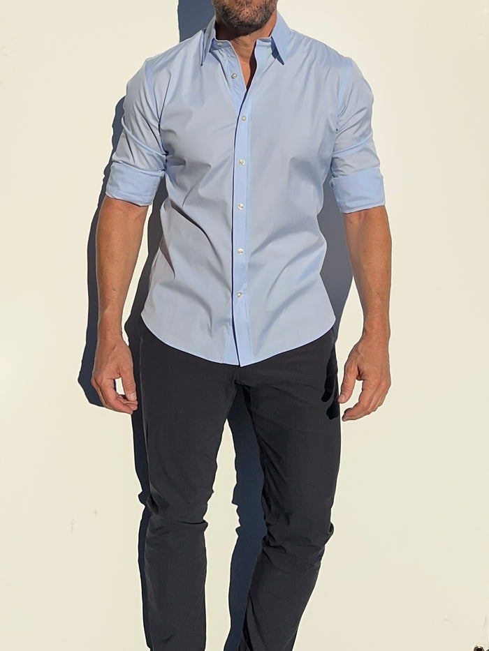 A model wearing a long-sleeved light blue dress shirt with a collar, button-up shirt.
