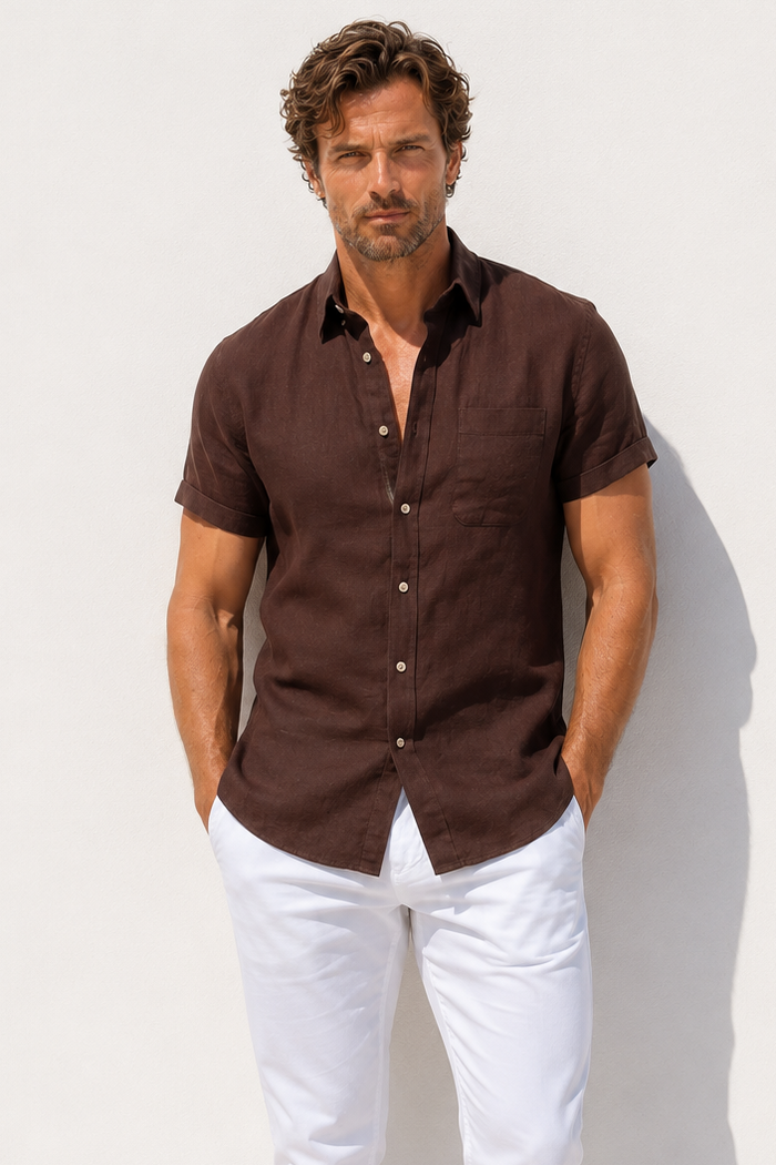 Man wearing a brown shirt and white pants against a white background