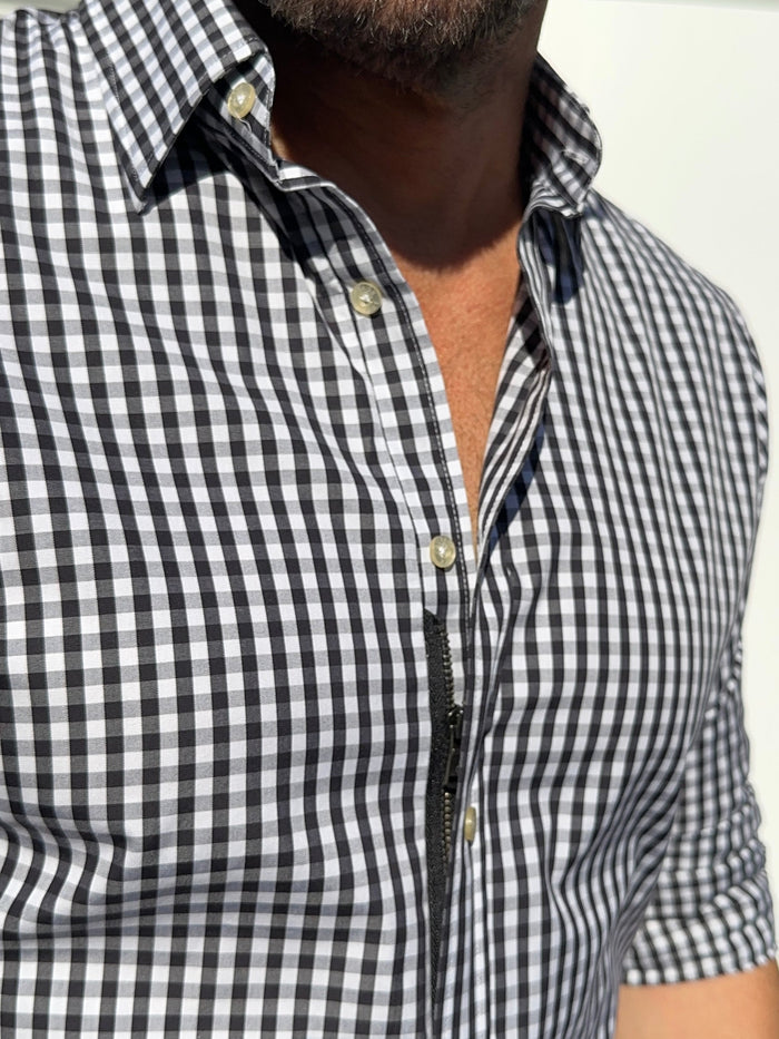 Black and white checkered shirt worn by a person on a plain background