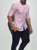 Person wearing a light pink shirt and dark pants on a white background